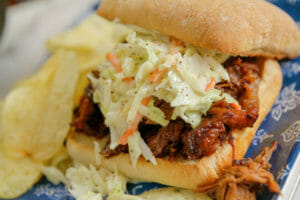 Burger on a bun topped with creamy Traditional Coleslaw made with Blue Plate Mayonnaise