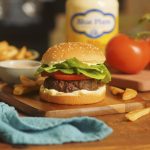 burger on a bun dressed with lettuce, tomato and blue plate mayonnaise