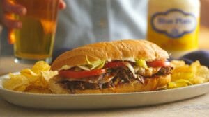 Debris Po-Boy Sandwich With Blue Plate Mayonnaise Jar And Beer In The Background