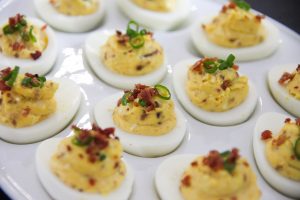 Bacon and Cheddar Deviled Eggs arranged on a serving platter