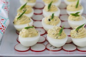 Caper and Lemon Deviled Eggs arranged on a party platter