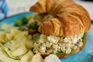 Southern Tuna Salad on a sliced croissant served with potato chips on the side