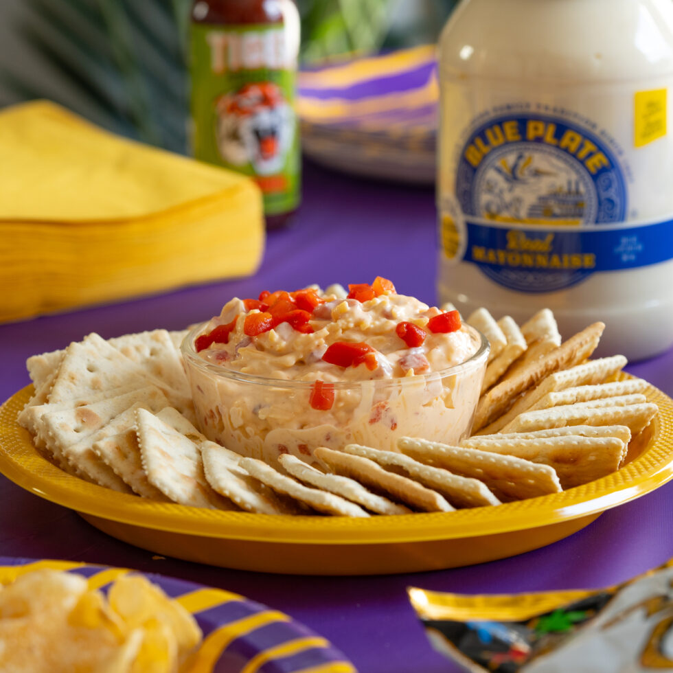 A bowl of cheesy pimento tiger dip with crackers