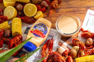 boiled crawfish on a table with boiled corn, potatoes with hot & spicy crawfish dipping sauce