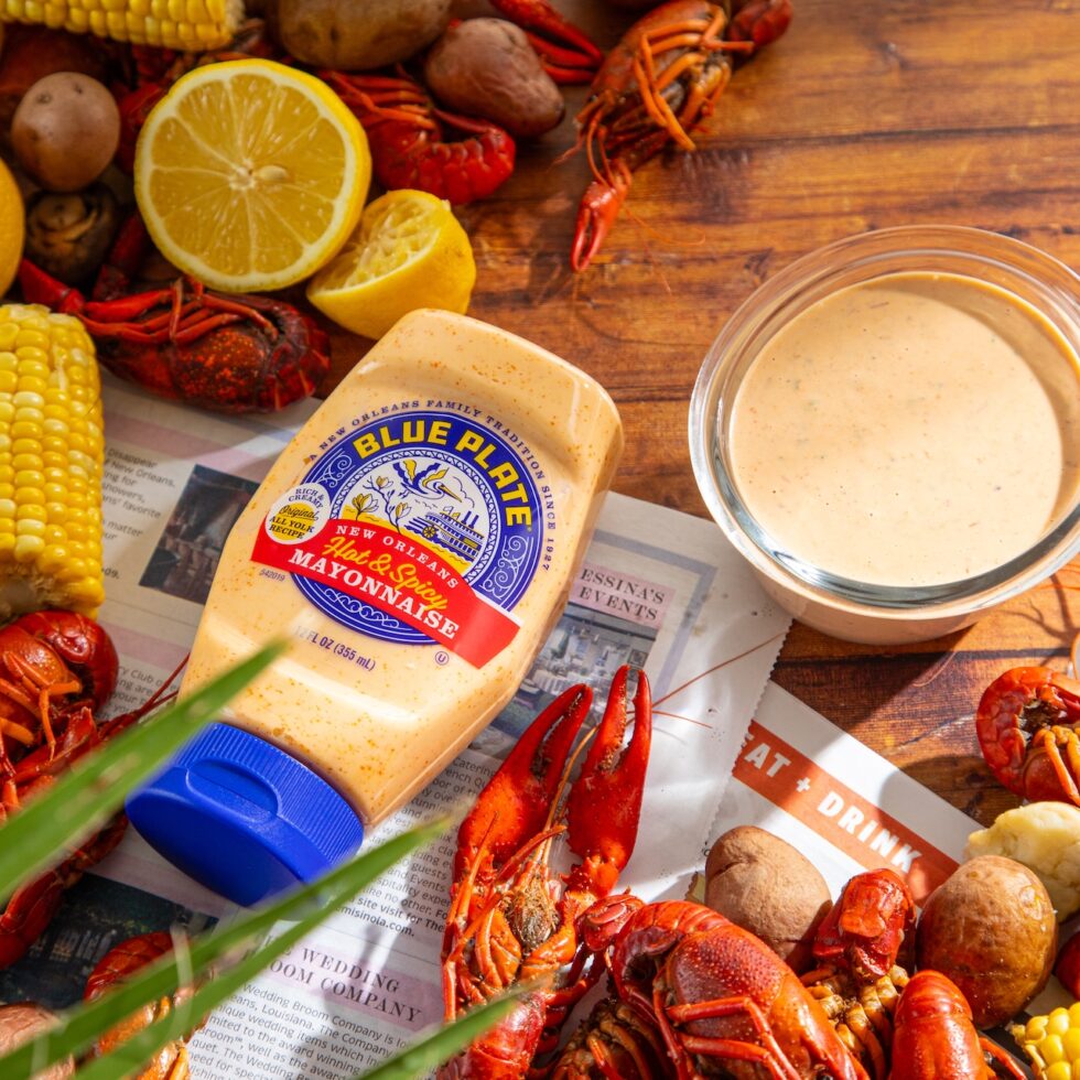 boiled crawfish on a table with boiled corn, potatoes with hot & spicy crawfish dipping sauce