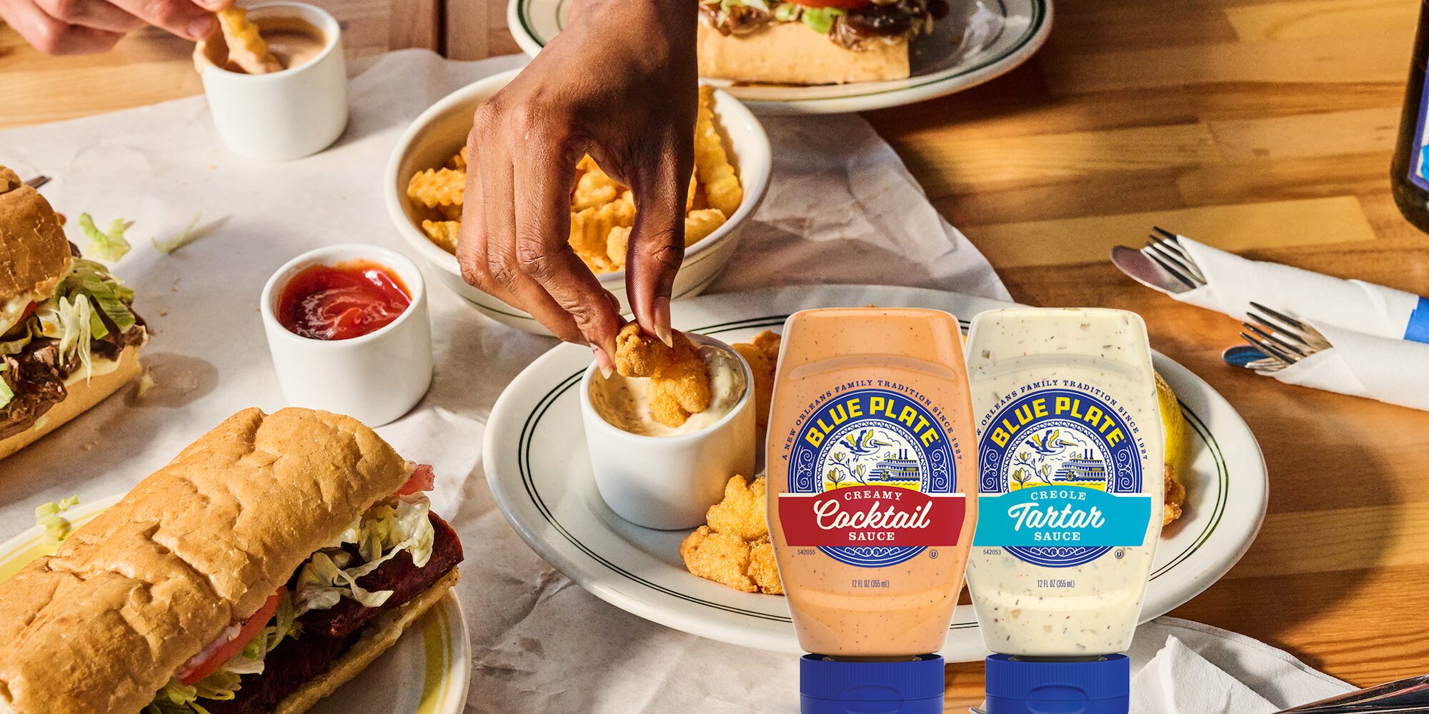 Blue Plate Cocktail and Tartar sauces with seafood feast and hand dipping shrimp into sauce